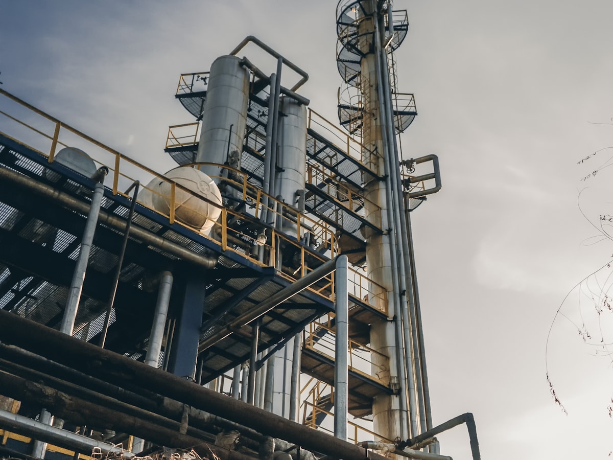Petrokimya tesisinde distilasyon kolonu ve proses boruları — Seven Towers toluen tedariği, boya, vernik ve tiner üretiminin aromatik solventi