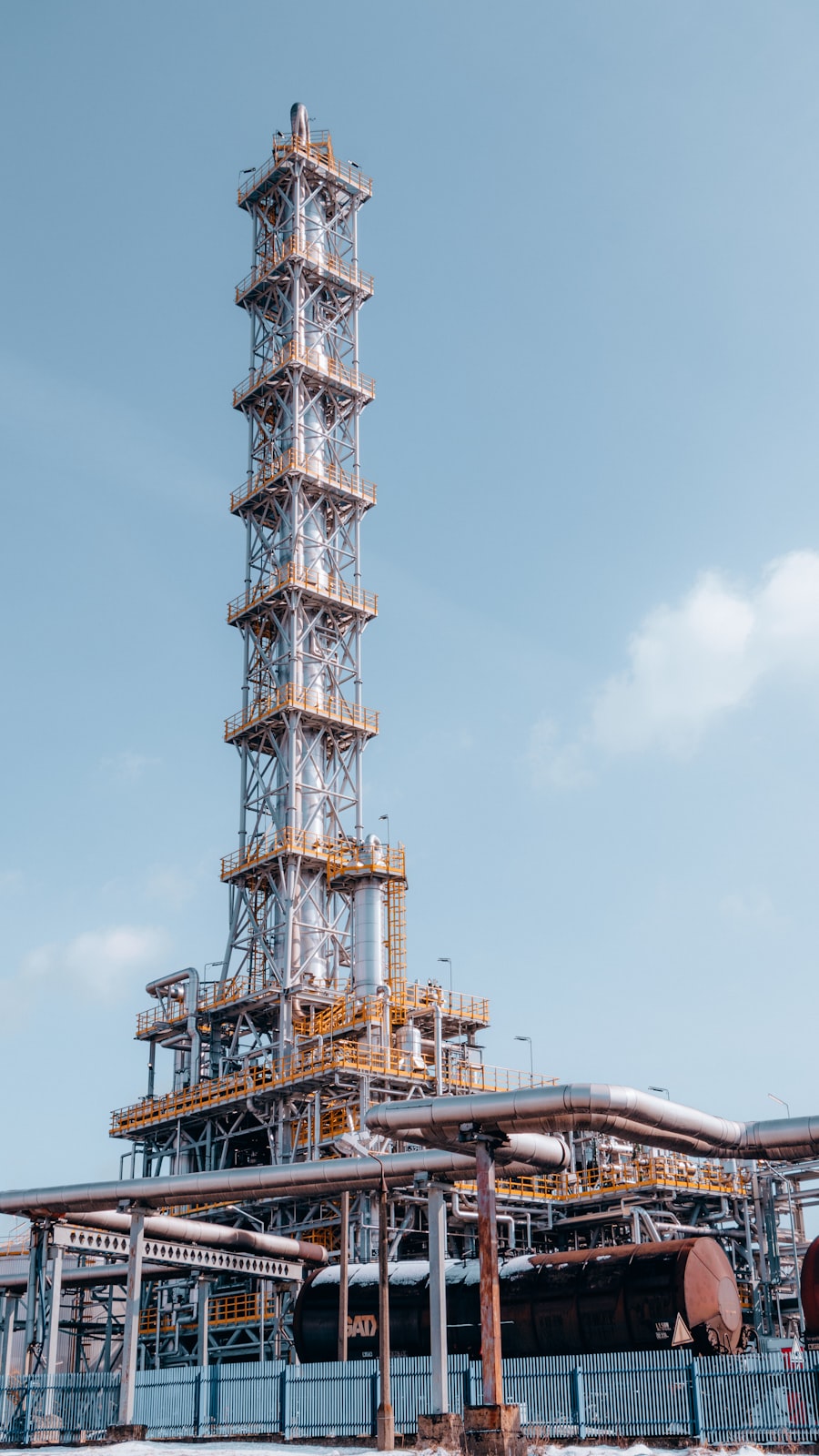Rafineride yükselen distilasyon kolonu — Seven Towers güvenilir kimyasal tedarik ve şeffaf süreç yönetimi
